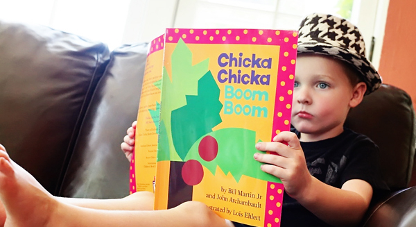 Boy reading chicka chicka boom boom book