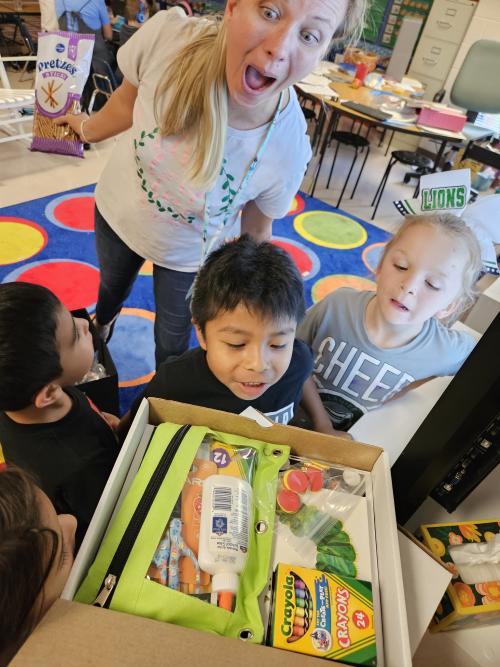teacher and kids looking at literacy kit
